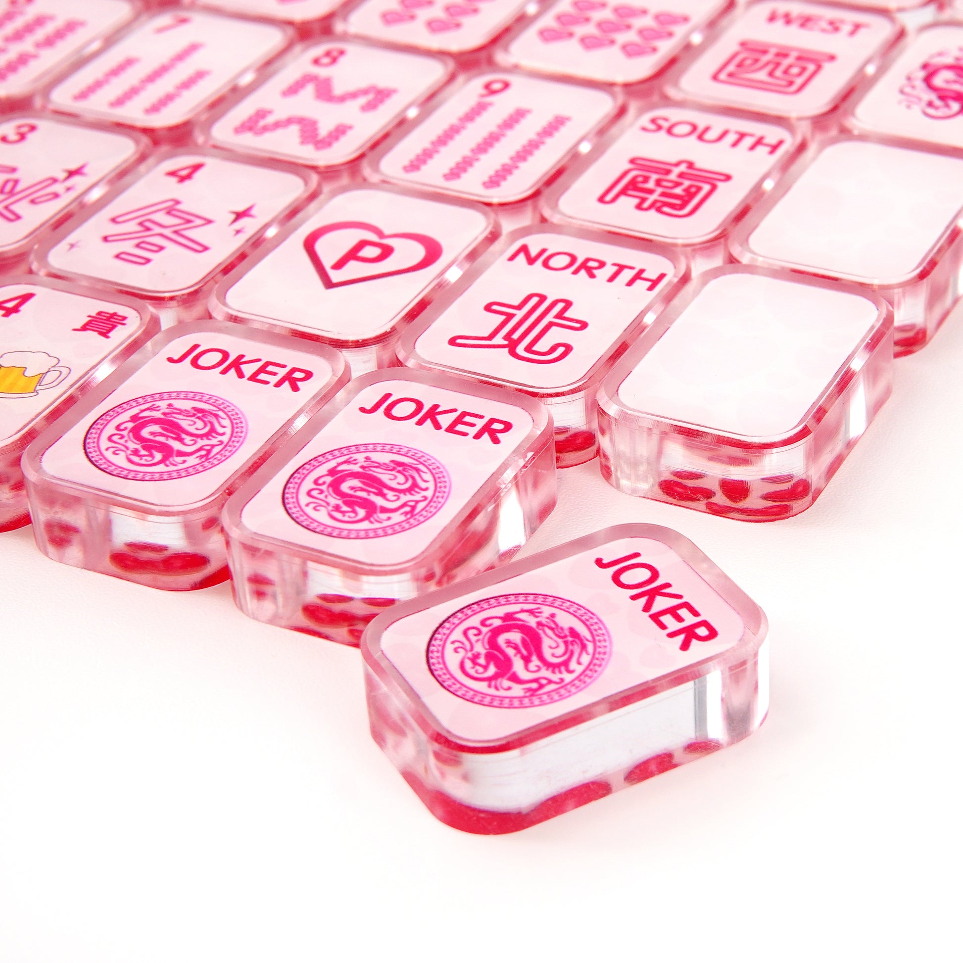 Close‑up of acrylic mahjong tile showing polished rounded edges and vibrant pink detailing