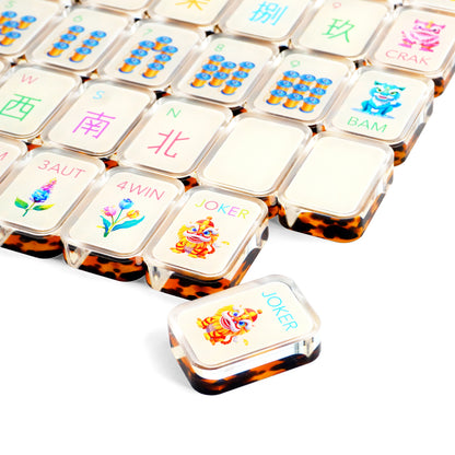 Close-up of designer tortoise shell mahjong tiles with colorful artwork and amber backs