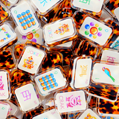 Luxury tortoise shell mahjong set with amber brown tiles and colorful designer artwork