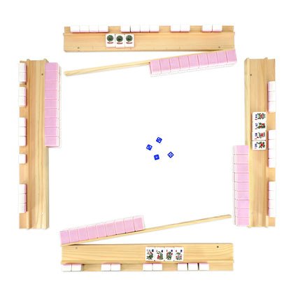 Pink mahjong set arranged for game play with wooden racks and tiles