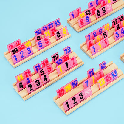 Close up of wooden racks holding colorful numbered tiles for rummy game